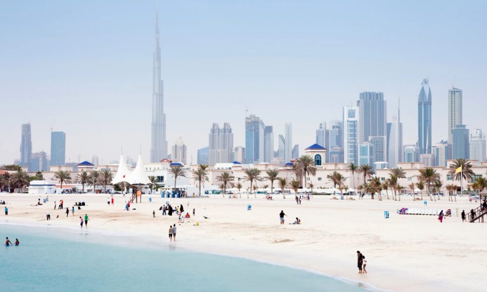 UAE employment law guide showing Dubai Courts building with legal documents and employment contract on desk