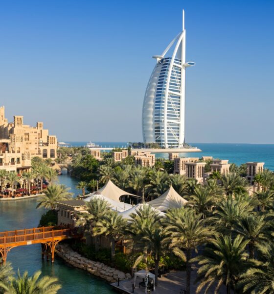 "Stunning aerial view of Dubai's coastline featuring golden beaches, turquoise waters, and luxury resort pools along JBR Beach"